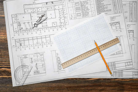 Drawing sketches are lying on a wooden surface with a pencil and a rulerの写真素材