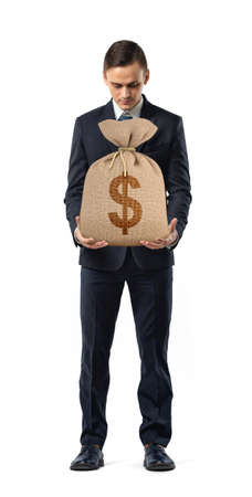 A businessman on white background holding a sack with a dollar sign printed on it.の写真素材