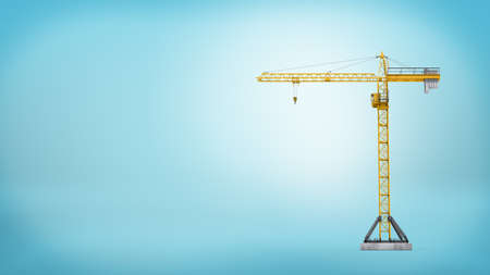 A yellow stationary tower crane without any load in full length on blue background.の写真素材