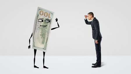 A businessman looking forward at a big money bill with arms and legs that is looking back at the man.の写真素材