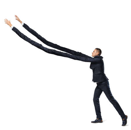 A businessman on white background in side view with extremely long arms trying to grab something above.の写真素材