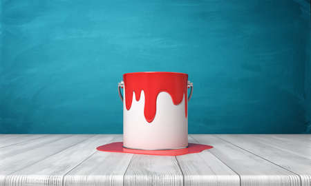 3d rendering of a metal bucket with red paint overflowing on its sides and on a wooden desk around it.の写真素材