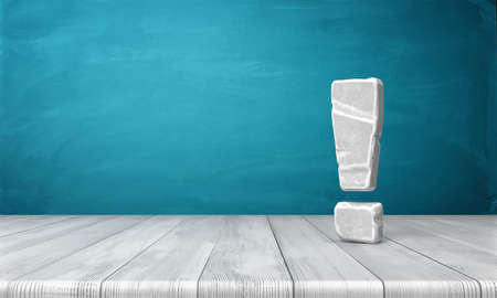 3d rendering of a grey-white exclamation mark made of stone standing on a wooden surface in front of blue background.の写真素材