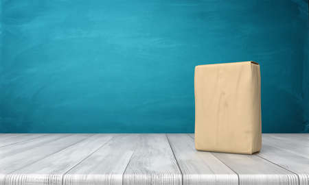 3d rendering of a single closed cement bag vertically placed on a wooden desk on blue background.の写真素材