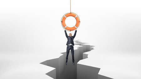 A tiny businessman holds on to a red life buoy hanging above a large earthquake rift.