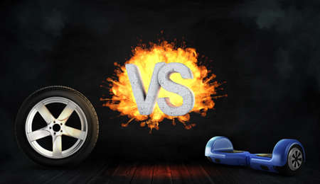 3d rendering of a flaming concrete letters VS stand between a car wheel and a blue self-balancing board.の写真素材