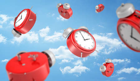 3d rendering of a many red round retro alarm clocks falling down on the background of a blue sky with white clouds.の写真素材