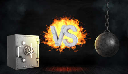 3d rendering of a retro iron safe box and a black wrecking ball with large exploding letters VS between them.の写真素材