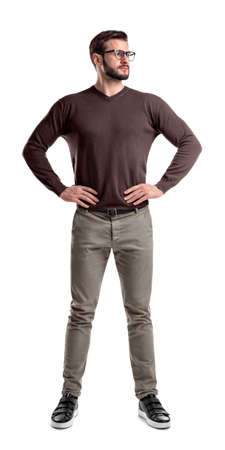 A bearded man in casual clothes stands with hands on his hips isolated on a white background.の写真素材