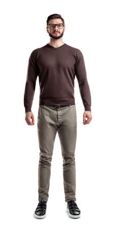 A young bearded man in casual wear stands with hands on his sides on a white background.の写真素材