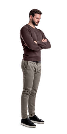 A bearded man in smart casual clothes stands in half-turn with arms folded and looks down.の写真素材