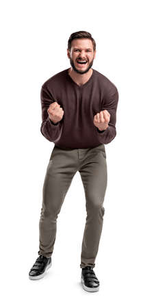 An aggressive bearded man in casual clothes shouts at camera, shows his teeth and holds fingers in tight fists.の写真素材