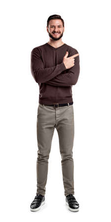 A bearded man in casual clothes smiles with his arms folded but still indicating sideways with his index finger.の写真素材