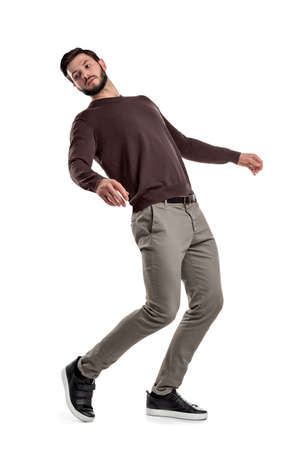 A serious looking bearded man in casual clothes stands in a half-turned view as if almost falling behind.の写真素材