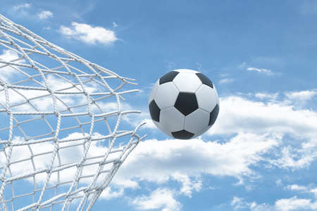 3d rendering of a football ball flying very strongly through a net and breaking it on a sky background.の写真素材