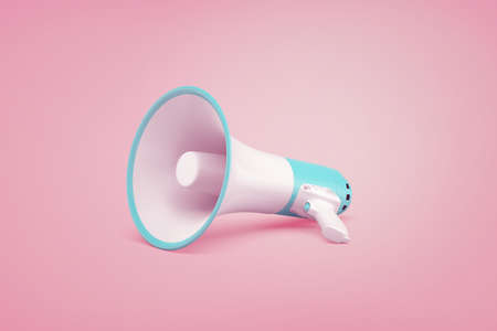 A white and blue portable cordless megaphone lies on a pastel pink background.の写真素材
