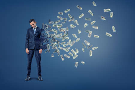 A sad businessman with head hanging down starts to deteriorate with his body turning into flying...