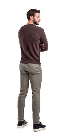 An adult bearded man in casual sweater stands in a back view half turned to look behind his shoulder.の写真素材