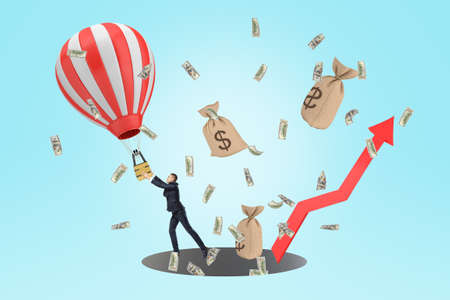 A composition with a businessman trying to keep hold of a hot-air balloon, with dollar bills and...