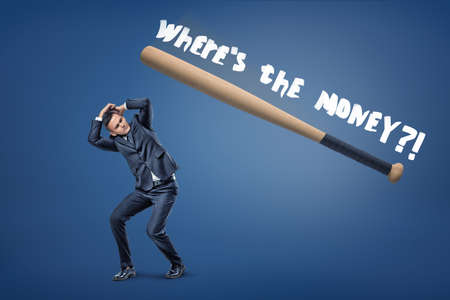 A small businessman hides from a huge basketball bat and large white words Wheres the money.