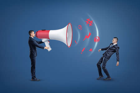 Businessman with huge loud-speaker uttering a message encoded in keyboard symbols, with a sound wave...