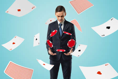 Man in suit looking down at poker chips floating in air with aces flying all around.の写真素材