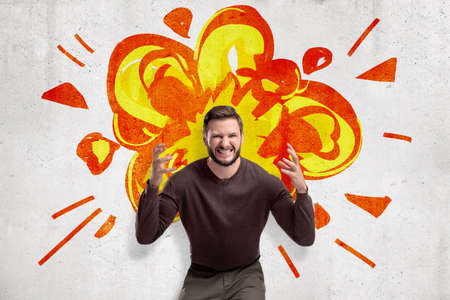 Young man in casual clothes making brain explosion gesture with cartoon explosion drawn on white...