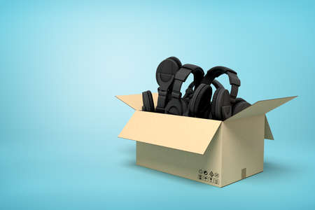 3d rendering of cardboard box full of black headphones on blue background.の写真素材