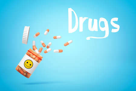 3d rendering of medical pills falling from a plastic jar with smiley face on it and DRUGS sign on blue backgroundの写真素材