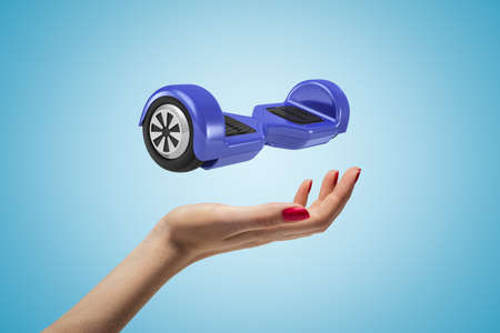 Female hand with blue hoverboard above on blue background