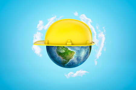 3d rendering of earth sphere with yellow hard hat on blue backgroundの写真素材