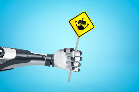 Robotic hand holding yellow robot road sign on blue backgroundの写真素材