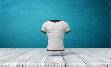 3d rendering of white close-fitting mens T-shirt with black edge piping, suspended in air above wooden surface on blue wall background.の写真素材