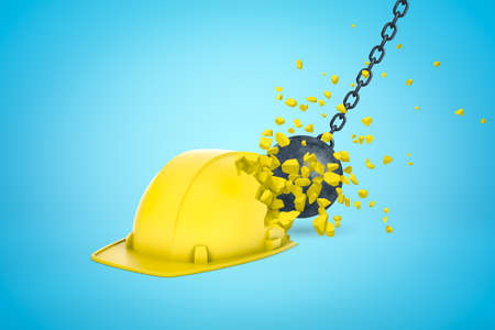 3d rendering of wrecking ball hitting and breaking yellow hard hat on light blue gradient background. Construction safety.の写真素材