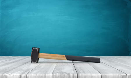 3d rendering of hammer with wooden handle half-painted black lying on wooden surface near blue copy space wall.の写真素材