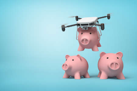 3d rendering of quadcopter carrying pink piggy bank and putting it down to two identic piggy banks standing on light blue background with copy space.の写真素材