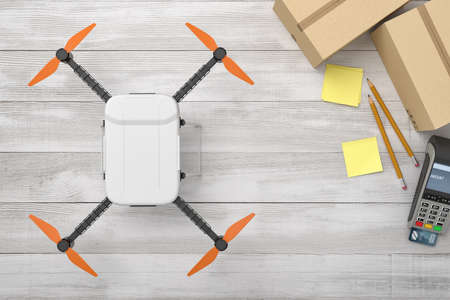 3d rendering of white drone with cardboard boxes, sticky notes, pencils and pin pad on white wooden desk backgroundの写真素材