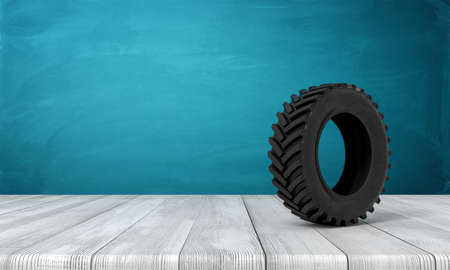 3d rendering of black tractor wheel on white wooden floor and dark turquoise backgroundの写真素材