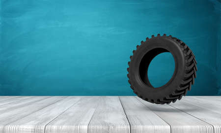 3d rendering of black tractor wheel on white wooden floor and dark turquoise backgroundの写真素材