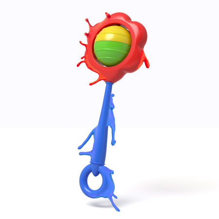 Red paint splashing over rattle toy on whiteの写真素材