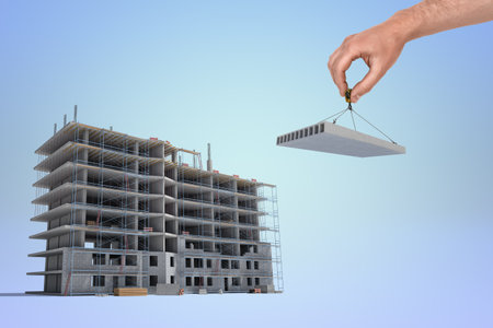 Hand placing the last piece on a construction siteの写真素材