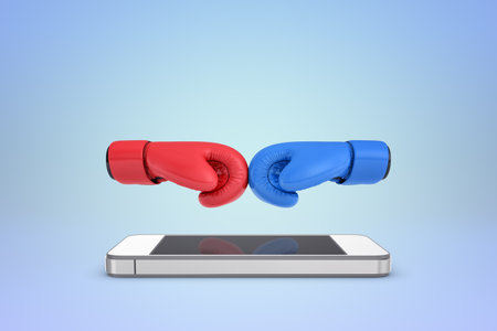 Red and blue boxing gloves on smartphoneの写真素材