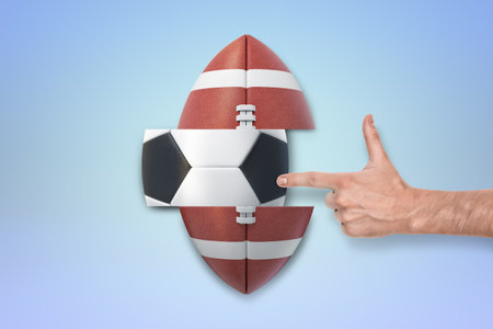 Finger pointing at an American football-soccer ballの写真素材