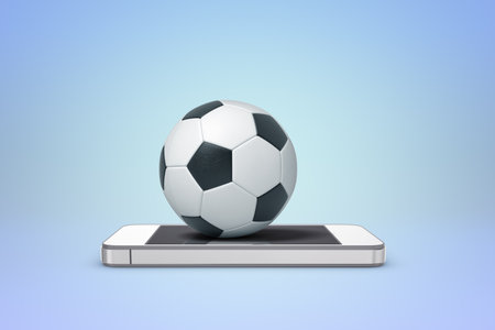 Soccer ball resting on mobile phoneの写真素材