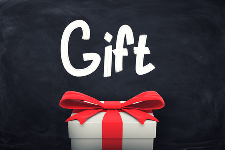Gift box with red ribbon on blackboardの写真素材