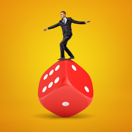 Businessman balancing on a giant red diceの写真素材