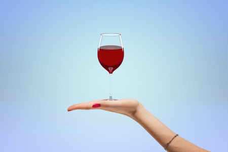Balancing wine glass on womans fingerの写真素材
