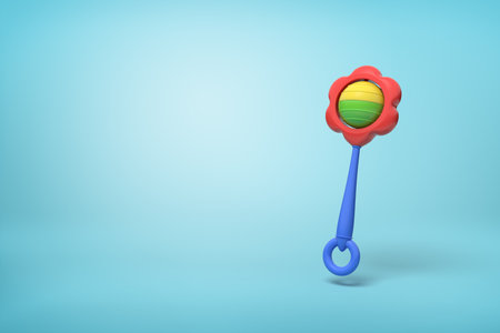 Colorful flower-shaped rattle on a seamless blue backgroundの写真素材