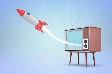 Rocket launching from old-fashioned TV on blue backgroundの写真素材