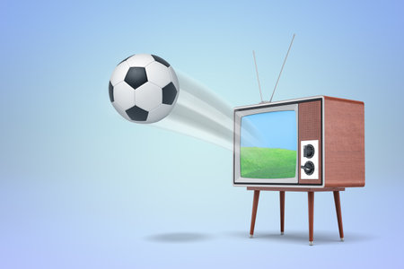 Retro TV set with a soccer ball exiting screenの写真素材